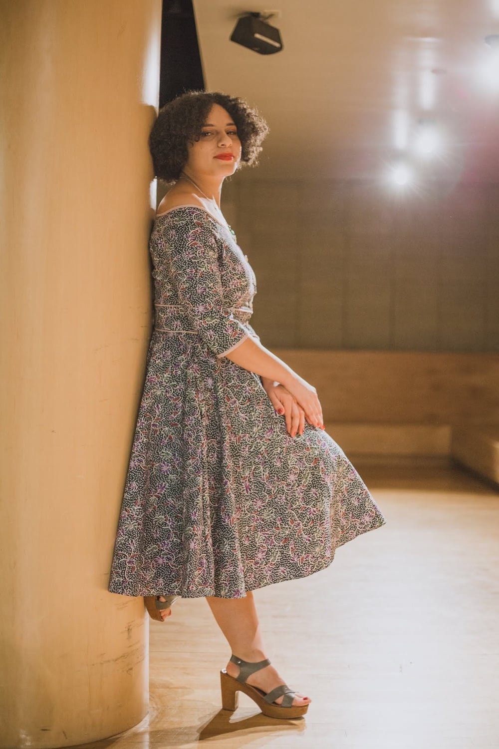 Un vestido gris floreado con falda amplia y manga tres cuartos.