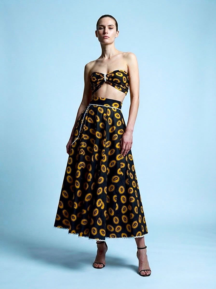 El conjunto Medallón: bandeau y falda midi amplia en negro con medallones dorados.