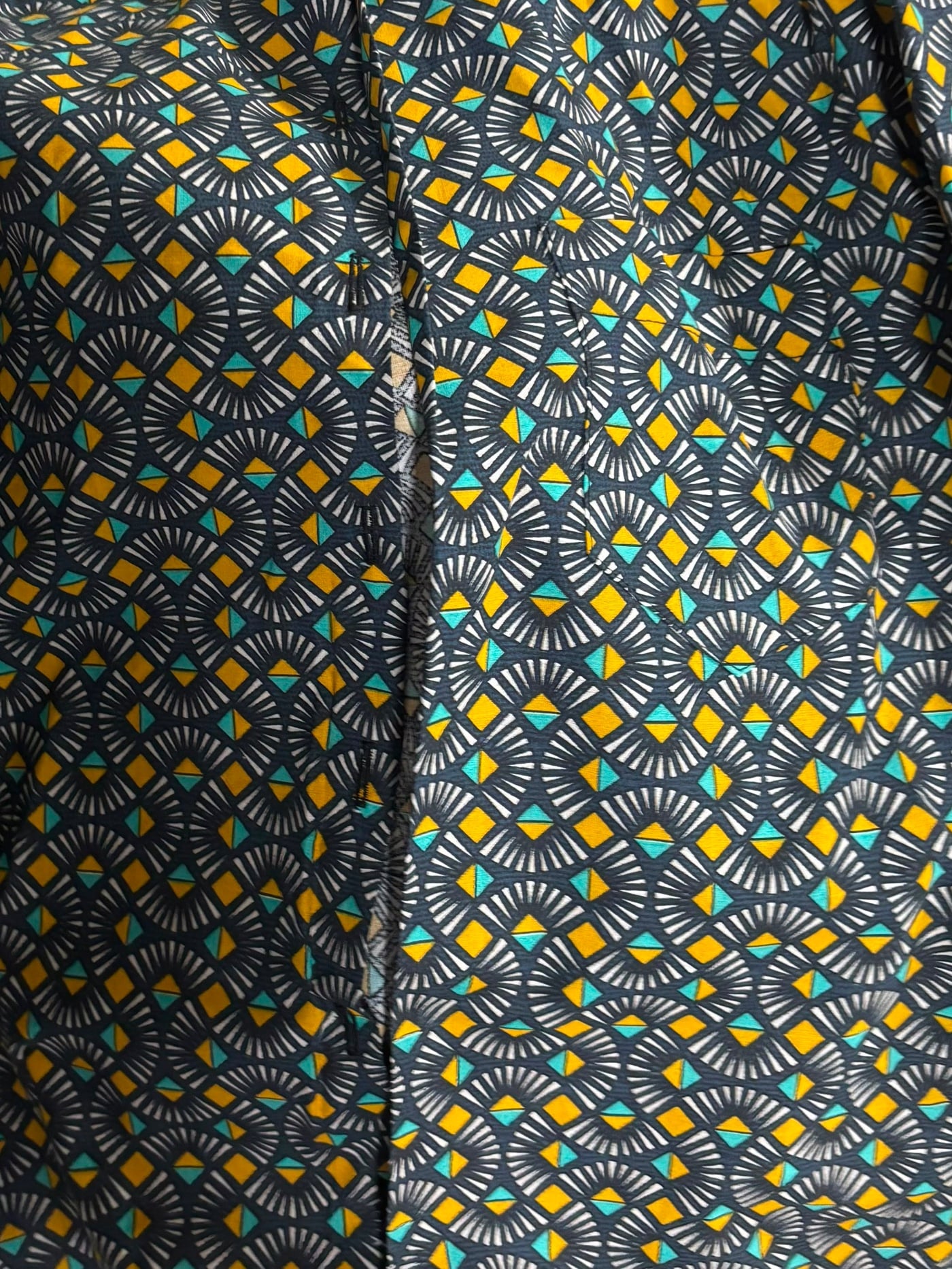 La camisa campera Yurumein en algodón wax verde azulado y amarillo, fotografiada en el taller.
